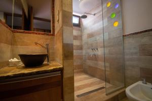 a bathroom with a sink and a glass shower at Tikay Humahuaca Refugio de Tierras in Humahuaca