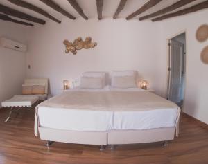 1 dormitorio blanco con 1 cama grande y 1 silla en Boutique Bed & Breakfast Casa Paco - adults only, en Vélez Rubio