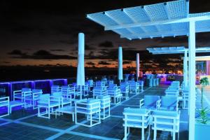 a row of white chairs on a roof at night at Sandos Papagayo in Playa Blanca
