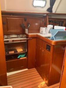 a small kitchen with wooden cabinets and a stove at Sea Bloom - Sleep & Sail in Tejo in Lisbon