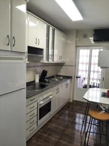 a kitchen with white cabinets and a cat sitting on the counter at Angel in Zamora