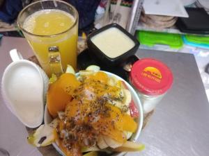 un plato de comida y un vaso de zumo de naranja en Casa sanacion Elixir en Pucallpa