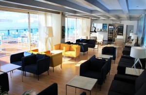 a waiting room with chairs and tables and windows at Sandos Papagayo in Playa Blanca