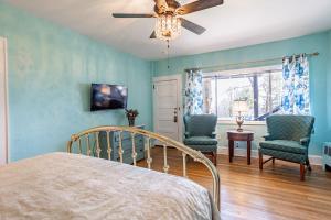 a bedroom with a bed and two chairs and a ceiling fan at Echo Mountain Inn in Hendersonville