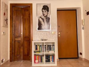 a book shelf with books and a picture of a woman at A.B Battistini Short Let's in Rome