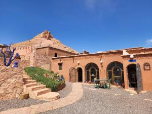 un edificio con una mesa y escaleras delante en Riad Paradise of Silence, en Aït Ben Haddou