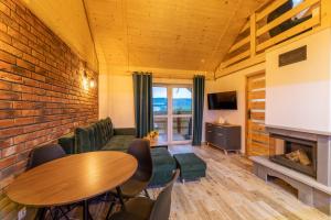 a living room with a table and a fireplace at Bieszczadzkie Tarasy in Ustrzyki Dolne