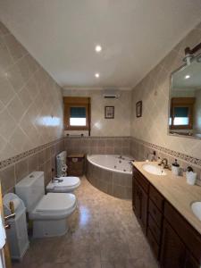 un bagno con due WC, una vasca e un lavandino di La casona de isa a Palazuelos de Eresma