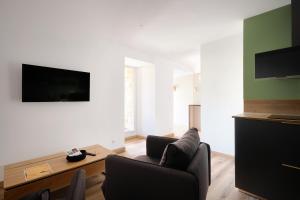 ein Wohnzimmer mit 2 Stühlen und einem Flachbild-TV in der Unterkunft Advitamrelais in La Rouquette