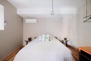 ein Schlafzimmer mit einem großen weißen Bett mit zwei Tischen in der Unterkunft Advitamrelais in La Rouquette
