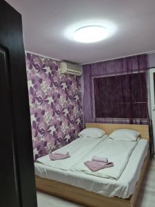 1 dormitorio con 1 cama con pared morada en House Slava en Veliko Tŭrnovo