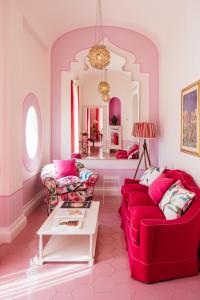 una sala de estar con 2 sofás rojos y una mesa. en Boutique Hotel Don Alfonso 1890, en SantʼAgata sui Due Golfi