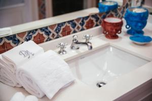 a bathroom sink with towels on a counter at Boutique Hotel Don Alfonso 1890 in SantʼAgata sui Due Golfi