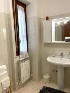 W łazience znajduje się umywalka, toaleta i lustro. w obiekcie Filo Guest House w mieście Perugia