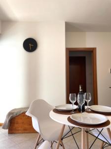 Filo Guest House في بيروجيا: طاولة مع كرسيين وكأسين للنبيذ