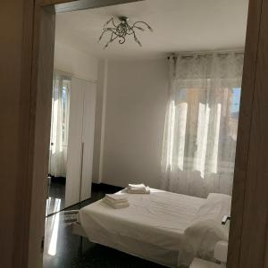 um quarto com uma cama branca e um lustre em SEA COTTAGE em Savona