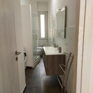 bagno con lavandino, servizi igienici e specchio di SEA COTTAGE a Savona