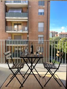 uma mesa com copos de vinho e 2 cadeiras numa varanda em Filo Guest House em Perugia