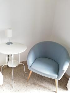 una silla azul sentada junto a una mesa blanca en Plaza Apartment, en Salerno