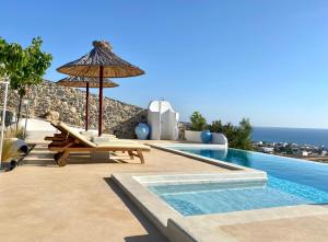a villa with a swimming pool and an umbrella at Stelani Villas & Suites in Kalamaki