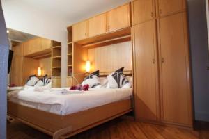 a bedroom with a large bed with wooden cabinets at ApartaSuites London Emerald in London