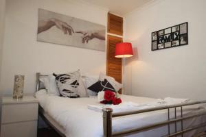 a bedroom with a bed and a red lamp at ApartaSuites London Emerald in London