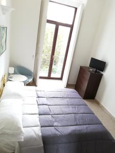 ein Schlafzimmer mit einem großen Bett und einem Fenster in der Unterkunft Plaza Apartment in Salerno