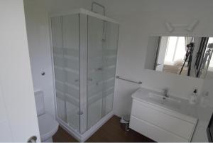 uma casa de banho branca com um WC e um espelho. em Casa maria em Celorio