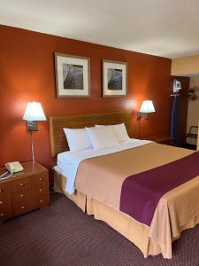 a hotel room with a large bed and two lamps at Executive Inn Schenectady Downtown in Schenectady