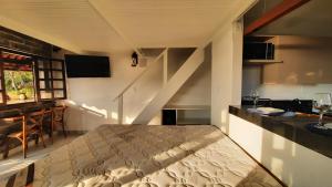 - une chambre avec un lit dans une pièce avec un escalier dans l'établissement Bangalô Aconchegante de Frente para o Mar, à Prado