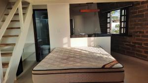 a bed in a room with a brick wall at Bangalô Aconchegante de Frente para o Mar in Prado +23 photos