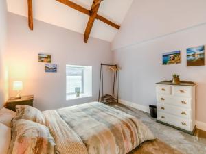 a bedroom with a bed and a dresser and a window at Point House in Milford Haven