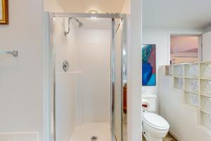 a white bathroom with a shower and a toilet at Marcia's Mercer Lake Chateau in Florence