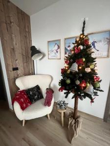 Un árbol de Navidad en una sala de estar junto a una silla en Ski Apartment Hillside, en Dolný Kubín