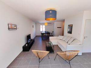 uma sala de estar com um sofá branco e cadeiras em Villa Vias Plage neuve em Vias