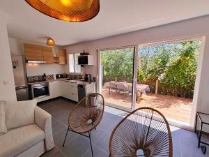 a kitchen and living room with a couch and chairs at Villa Vias Plage neuve in Vias