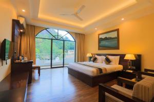 a bedroom with a bed and a large window at Kandyan Reach Hotel in Kurunegala