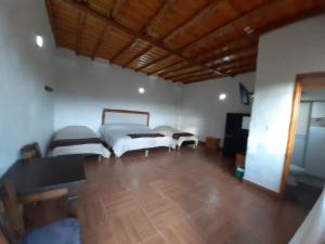 Habitación grande con 2 camas y suelo de madera. en Hotel Campestre Inaoska Ecospa, en Nobsa