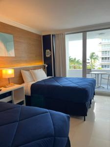 フォート・ローダーデールにあるOcean Manor Tiki Sunset Retreatのベッド2台とバルコニー付きのホテルの部屋