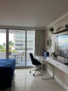 a bedroom with a desk and a tv and a chair at Ocean Manor Tiki Sunset Retreat in Fort Lauderdale