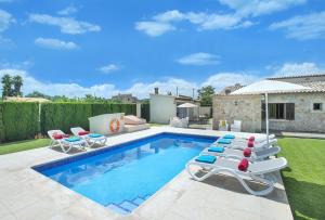 a swimming pool with lounge chairs and a house at Owl Booking Villa Tofol - Ideal For Family and Friends in Pollença