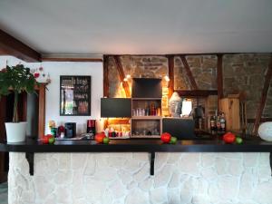 un bar en una habitación con una pared de piedra en La Petite Auberge, 