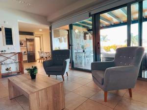 a living room with two chairs and a coffee table at Villa Lía by SunHousesCanarias in Salobre