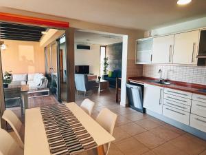 a kitchen and living room with a table and chairs at Villa Lía by SunHousesCanarias in Salobre