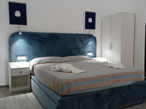 um quarto com uma cama com uma cabeceira azul em Residenza Napoletana em Nápoles