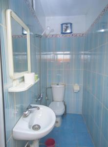 bagno piastrellato blu con lavandino e servizi igienici di Hotel TOURAGHINE a Chefchaouen