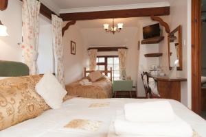 1 dormitorio con 2 camas y TV. en Burton Farmhouse, en Kingsbridge