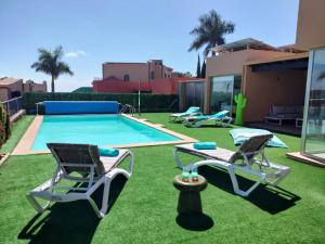 un cortile con 2 sedie e una piscina di Villa Lía by SunHousesCanarias a Salobre