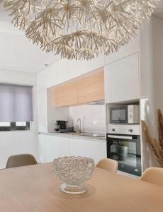 a kitchen with a dining table with a chandelier at Casa dos Avós in Castelo de Paiva