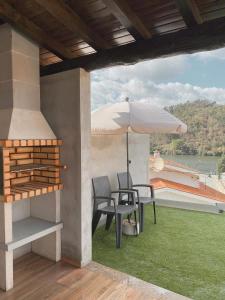 a patio with a table and an umbrella at Casa dos Avós in Castelo de Paiva